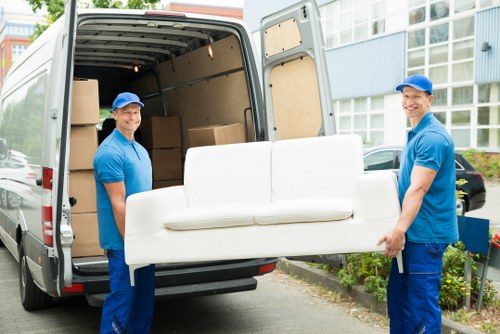 Front view of a man with a van service vehicle parked outside a property